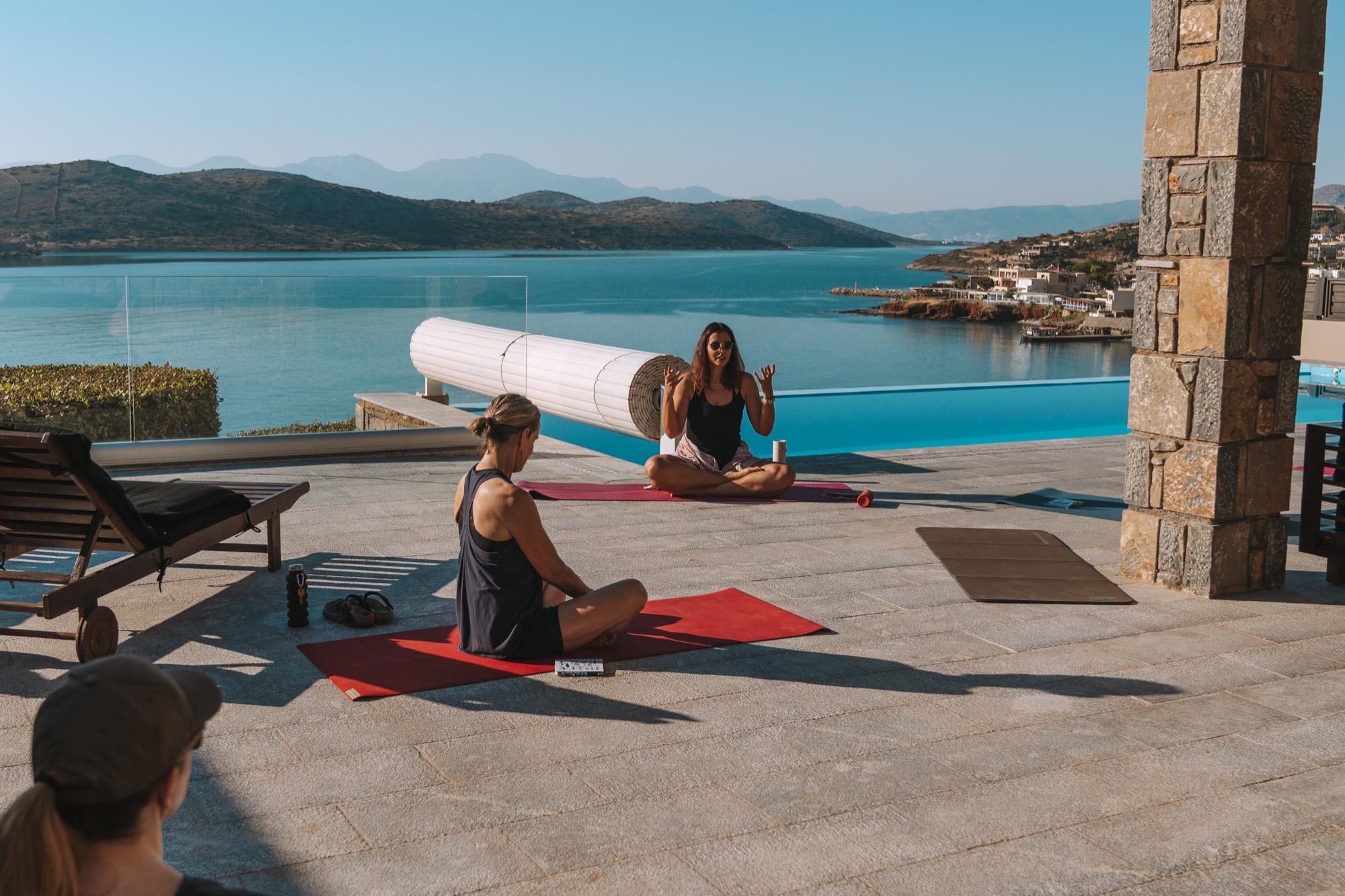 Stretching on mats by the pool above the sea